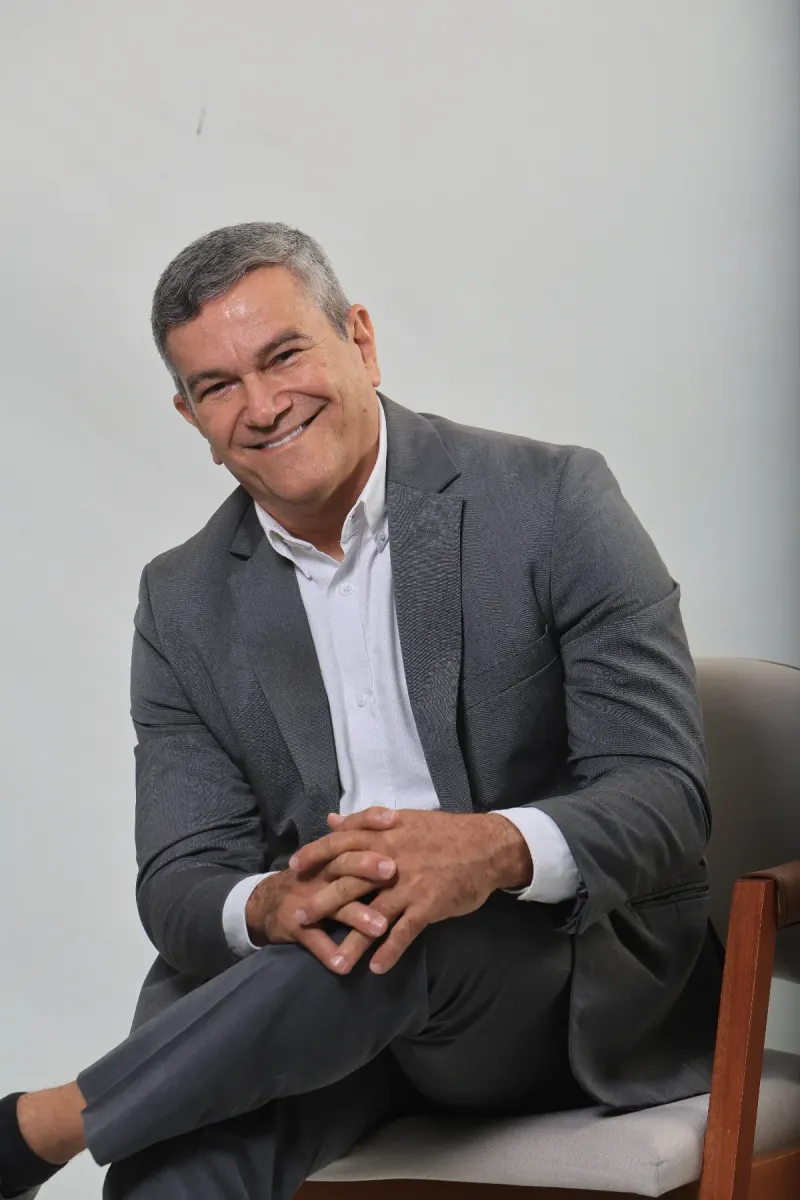Flávio Cesário sorrindo, em retrato de estúdio